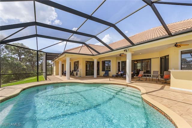 view of pool with glass enclosure, ceiling fan, and a patio area