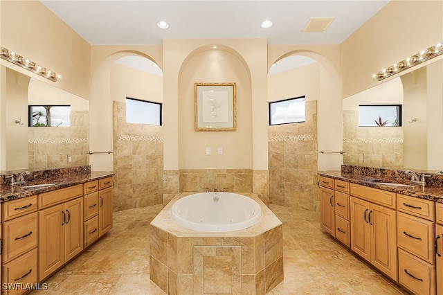 bathroom featuring vanity and a relaxing tiled tub