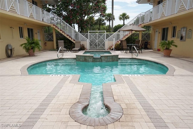 view of swimming pool with an in ground hot tub and a patio