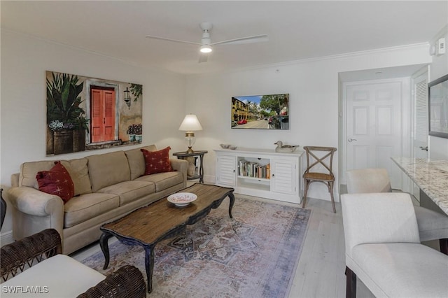 living room with ceiling fan, crown molding, and light hardwood / wood-style flooring