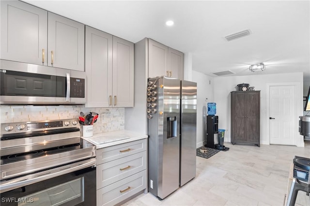 kitchen with decorative backsplash, appliances with stainless steel finishes, and gray cabinetry