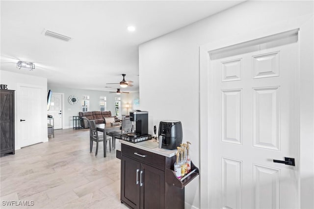 kitchen with ceiling fan and dark brown cabinets