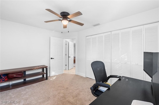 carpeted office space featuring ceiling fan