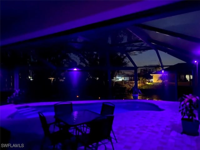 pool at twilight featuring glass enclosure