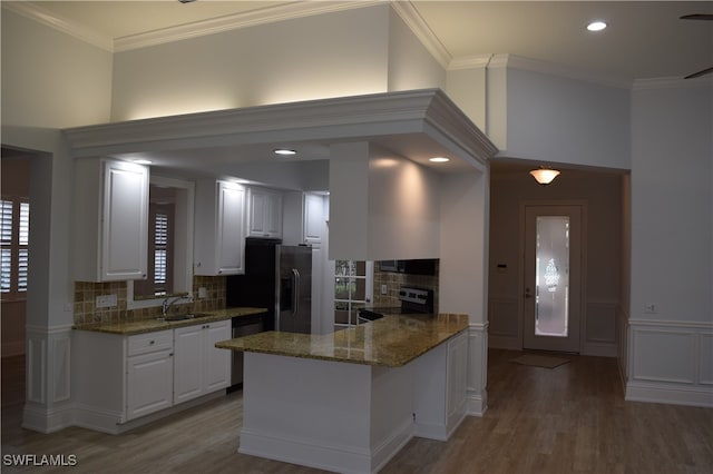 kitchen featuring sink, white cabinetry, tasteful backsplash, appliances with stainless steel finishes, and kitchen peninsula