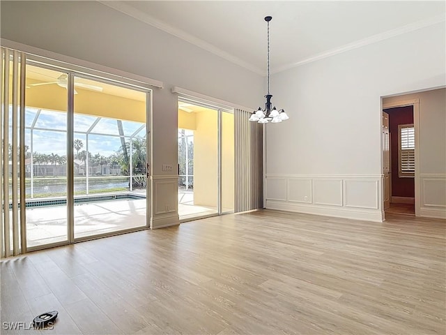 interior space featuring an inviting chandelier, ornamental molding, and light wood-type flooring