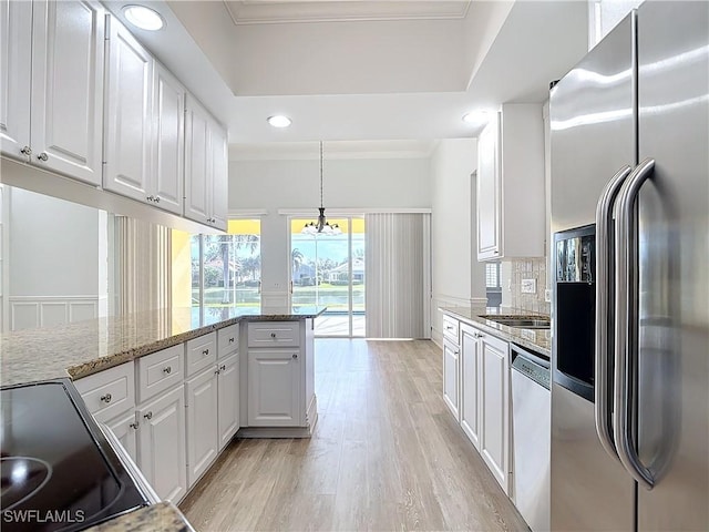 kitchen featuring light stone counters, pendant lighting, stainless steel appliances, decorative backsplash, and white cabinets