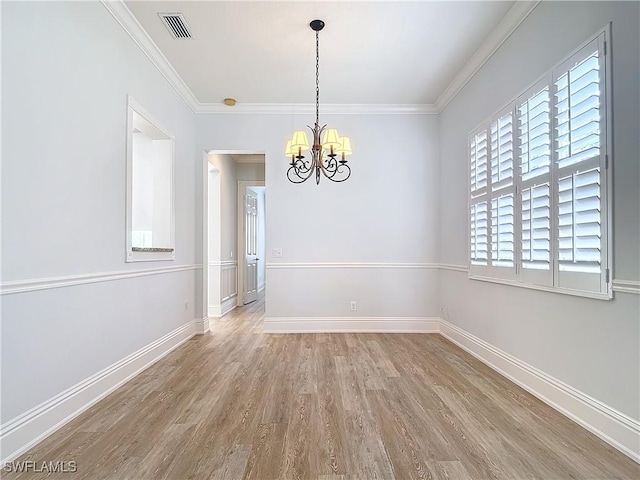 unfurnished room with an inviting chandelier, ornamental molding, and wood-type flooring