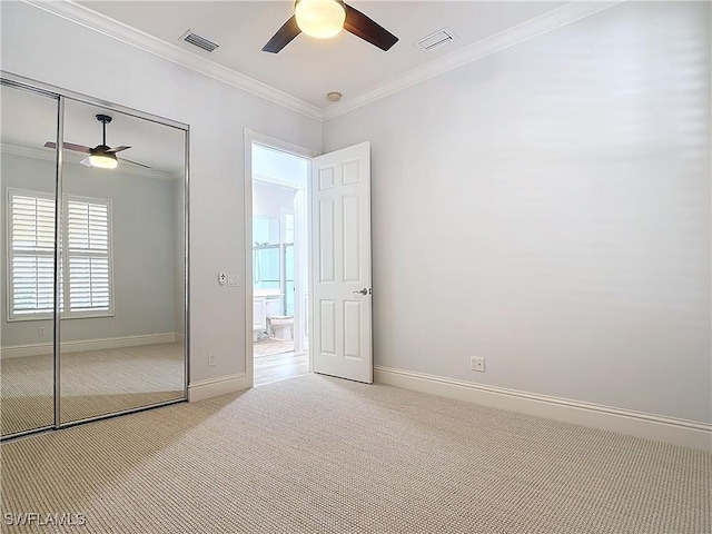 unfurnished bedroom featuring ceiling fan, ornamental molding, light carpet, and a closet