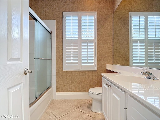 full bathroom featuring tile patterned flooring, vanity, bath / shower combo with glass door, and toilet