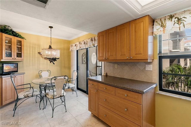 kitchen featuring a notable chandelier, decorative light fixtures, decorative backsplash, light tile patterned floors, and ornamental molding