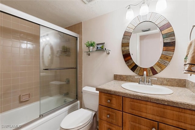 full bathroom with vanity, combined bath / shower with glass door, a textured ceiling, and toilet