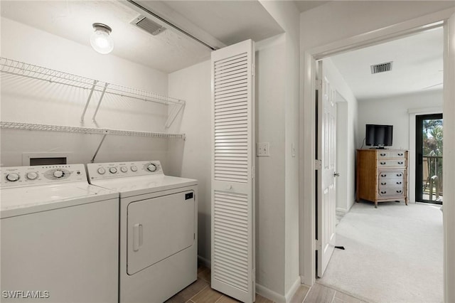 laundry room featuring washing machine and clothes dryer and light carpet