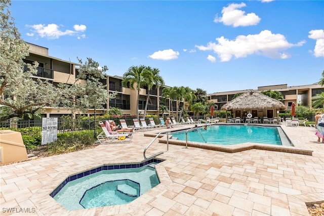 view of swimming pool with a patio area and a community hot tub