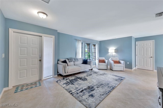 living area with light tile patterned floors, visible vents, and baseboards