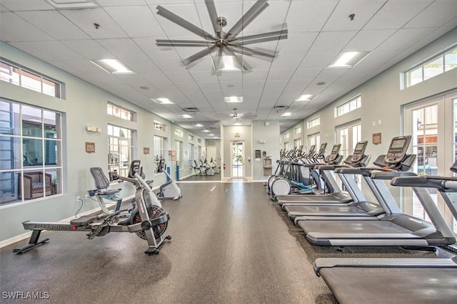 exercise room with a paneled ceiling, plenty of natural light, and ceiling fan