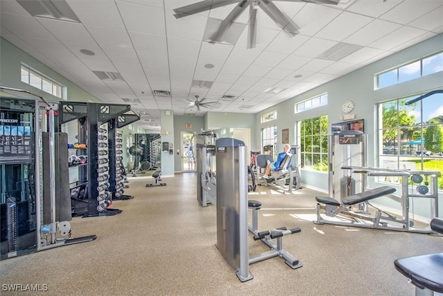 exercise room featuring ceiling fan and a drop ceiling