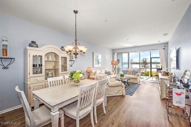 dining area with hardwood / wood-style flooring and a chandelier