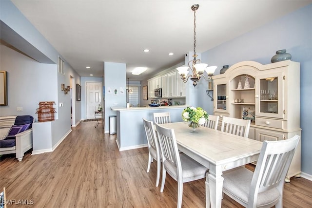 dining room with a notable chandelier and light hardwood / wood-style floors