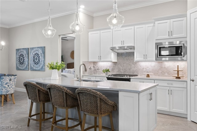 kitchen featuring white cabinets, sink, stainless steel appliances, and a kitchen island with sink