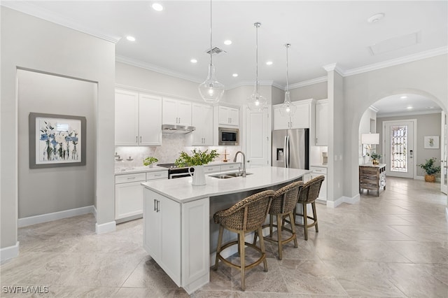 kitchen with white cabinets, stainless steel appliances, a center island with sink, and sink