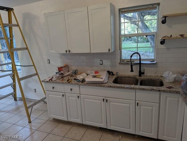 kitchen with white cabinetry, sink, and light tile patterned floors