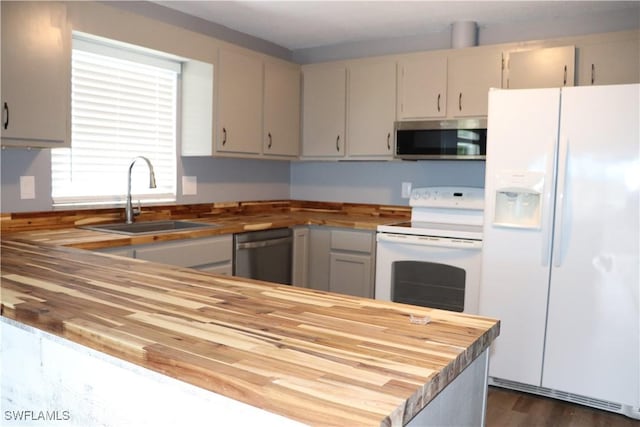 kitchen featuring dark hardwood / wood-style flooring, wooden counters, stainless steel appliances, and sink