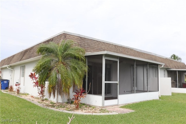 view of side of home featuring a yard and a sunroom