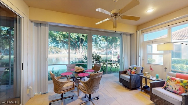 sunroom / solarium with a water view and ceiling fan