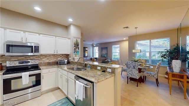 kitchen with kitchen peninsula, appliances with stainless steel finishes, white cabinetry, and sink