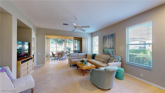 tiled living room featuring ceiling fan and plenty of natural light