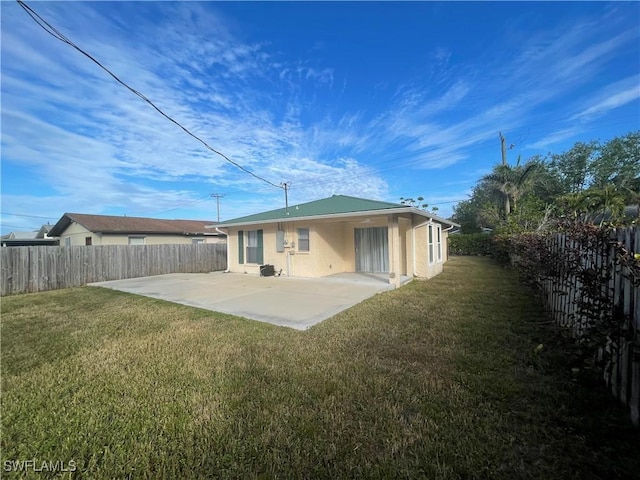 rear view of house featuring a lawn and a patio