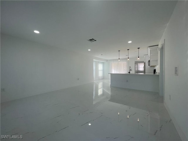 unfurnished living room featuring sink