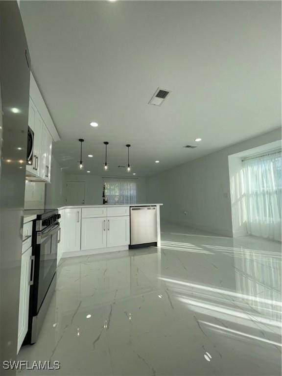 kitchen with kitchen peninsula, hanging light fixtures, white cabinets, and stainless steel appliances