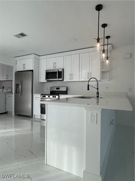 kitchen featuring pendant lighting, stainless steel appliances, white cabinetry, and sink