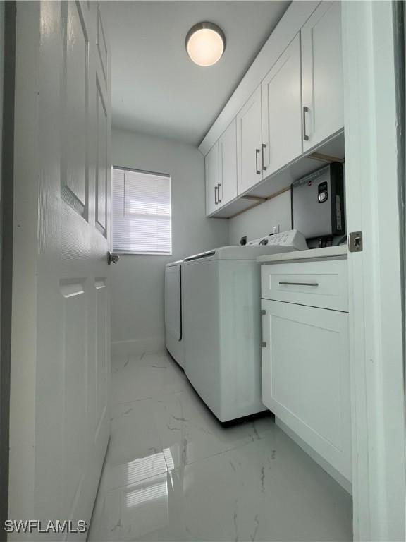 laundry room with washer and clothes dryer and cabinets