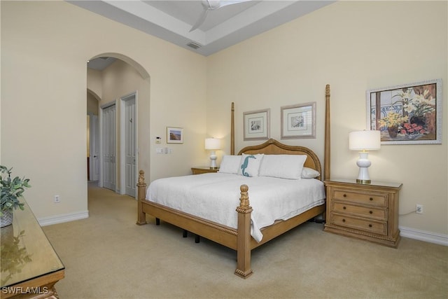 bedroom featuring a towering ceiling and light carpet