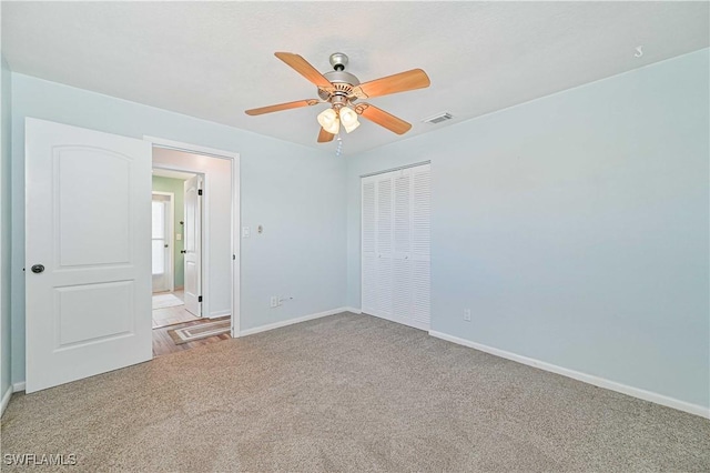 unfurnished bedroom featuring a closet, ceiling fan, and light colored carpet