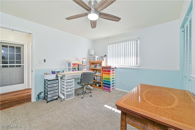 carpeted office space with ceiling fan