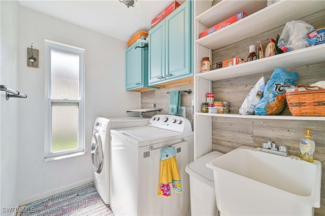 laundry area featuring cabinets, independent washer and dryer, and sink