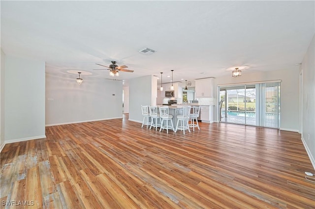 unfurnished living room featuring ceiling fan and light hardwood / wood-style flooring