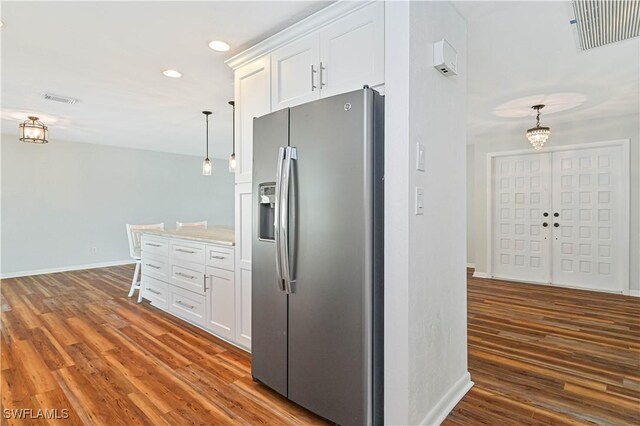 kitchen featuring stainless steel fridge with ice dispenser, dark hardwood / wood-style flooring, white cabinets, and pendant lighting