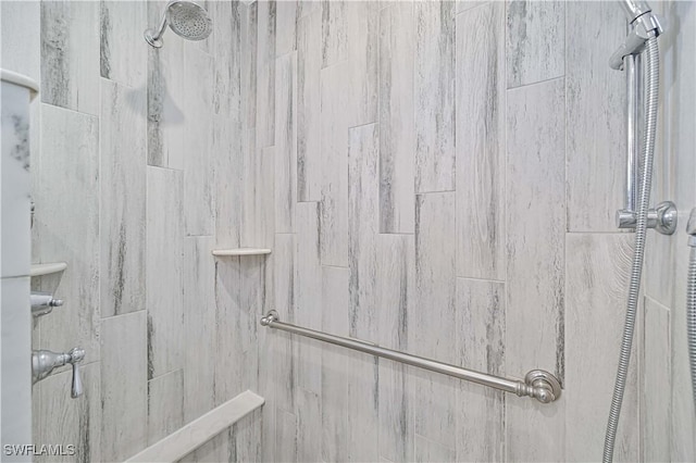 interior details featuring a tile shower