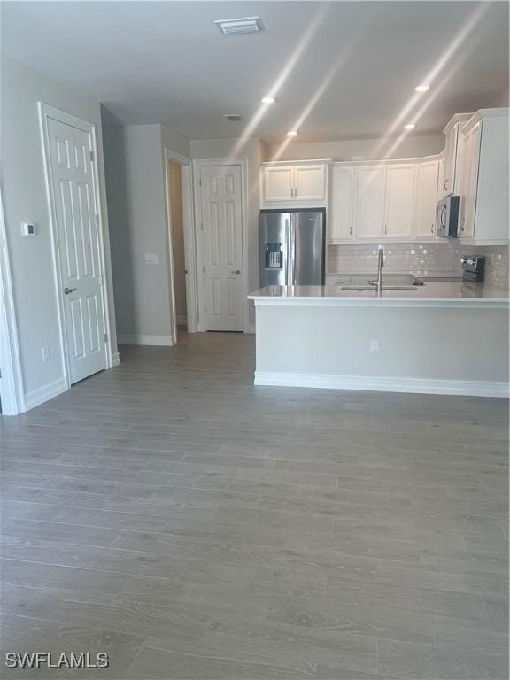 kitchen with backsplash, sink, white cabinets, and appliances with stainless steel finishes