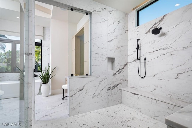 bathroom with a tile shower and a healthy amount of sunlight