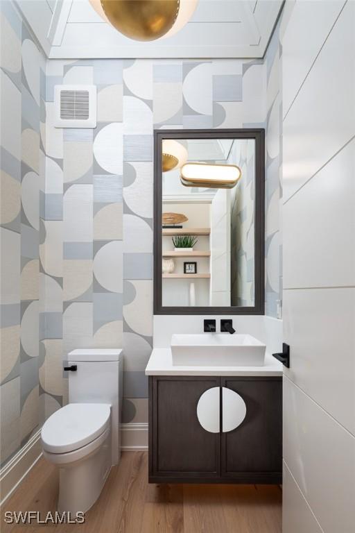 bathroom with hardwood / wood-style flooring, vanity, and toilet