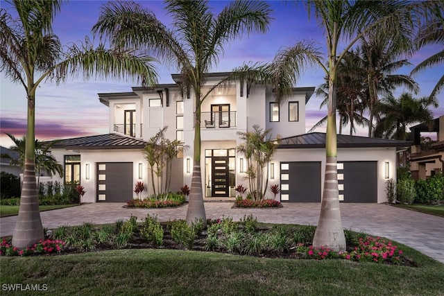 view of front of house with a garage, a balcony, and french doors