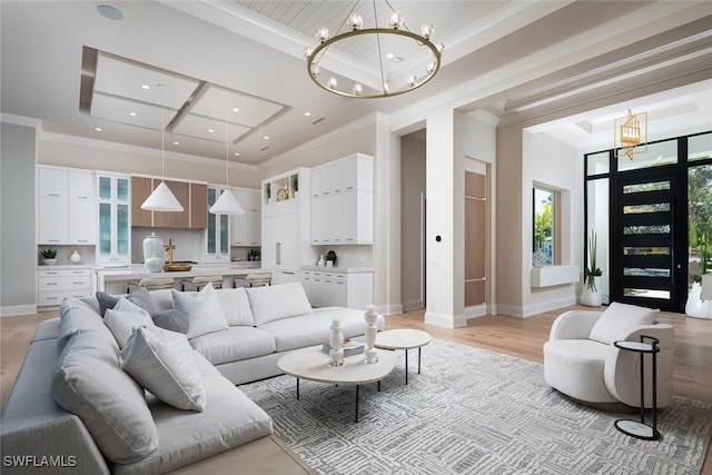 living room featuring a notable chandelier, crown molding, and light hardwood / wood-style flooring