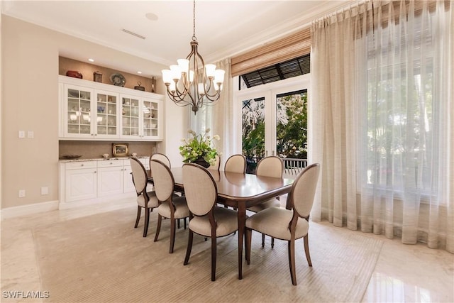 dining room with crown molding and a chandelier