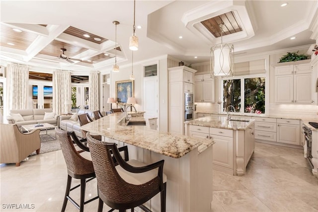 kitchen featuring a large island, sink, decorative light fixtures, and a kitchen bar